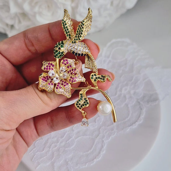 Goldene Brosche Kolibri, golden brooch, broche, spilla, Goldene Kolibri-Brosche mit Blume, bunten CZ-Steinen und weißer Perle – 18K vergoldetes Kupfer, romantisch-verspielter Schmuckstil